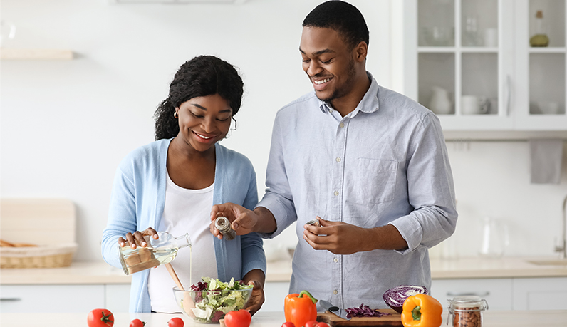 Casal preparando alimentos esposa grávida