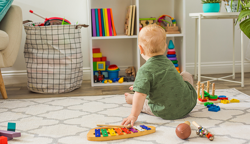 Bebê em frente a diversos brinquedos